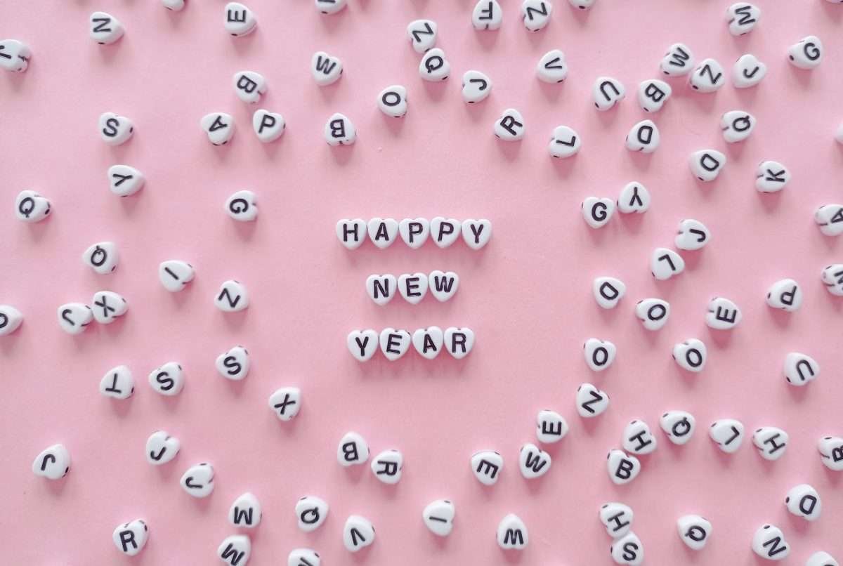 a happy new year greeting spelled with heart shaped letter tiles