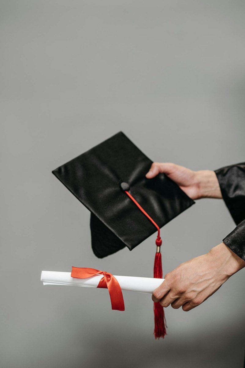 Person Holding Black Academic Hat